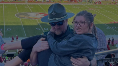 Photo of Image of Florida deputy carrying girl struggling to walk up stadium stairs at football game goes viral